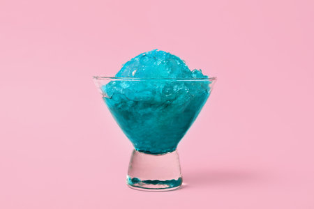 Shaving ice in glass dessert bowl on pink background, closeup