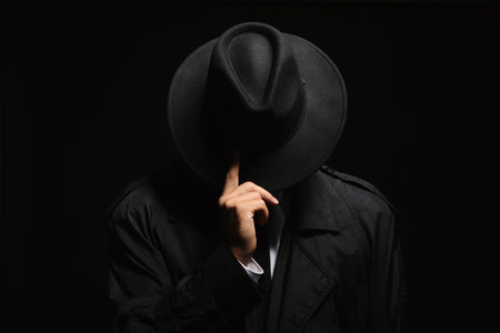 Old fashioned detective in hat on dark backgroundの写真素材