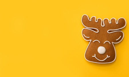 Christmas deer shaped gingerbread cookie on yellow background, top view. Space for textの写真素材