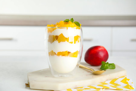 Tasty peach dessert with yogurt on white tableの写真素材