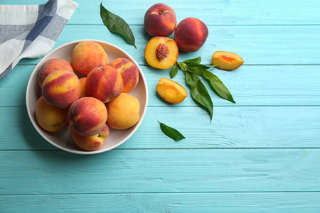 Fresh sweet peaches on turquoise wooden table, flat lay. Space for textの写真素材
