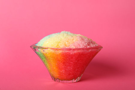 Rainbow shaving ice in glass dessert bowl on pink backgroundの写真素材