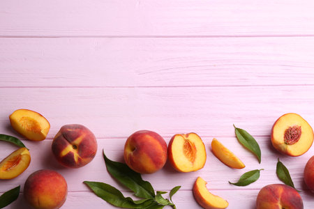 Fresh sweet peaches on pink wooden table, flat lay. Space for textの写真素材