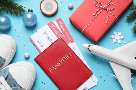 Flat lay composition with Christmas decorations, passport and airline tickets on light blue background. winter holidaysの写真素材