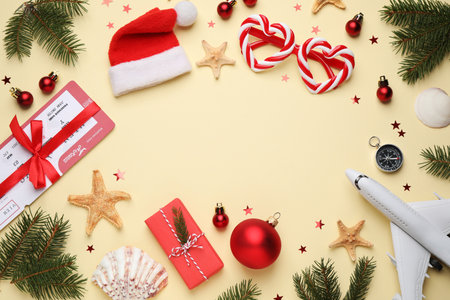 Frame with toy airplane, Santa hat, festive decor and space for text on yellow background, flat lay. christmas holidaysの写真素材