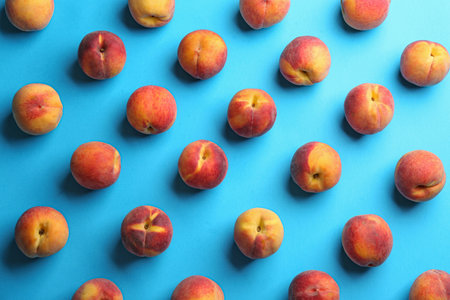 Fresh ripe peaches on light blue background, flat layの写真素材
