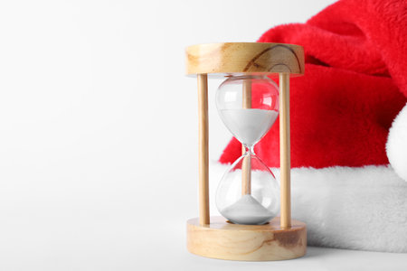 Hourglass and Santa hat on white background. christmas count downの写真素材