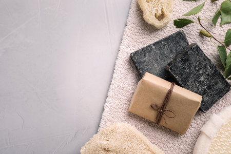Flat lay composition with natural tar soap on gray table. Space for text