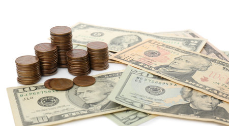 Dollar bills and coins isolated on white