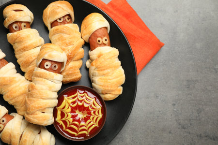 Spooky sausage mummies for Halloween party served on gray table, top view. Space for textの写真素材