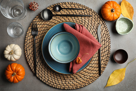 Seasonal table setting with pumpkins and other autumn decor on gray background, flat layの写真素材