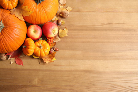 Flat lay composition with ripe pumpkins and autumn leaves on wooden table, space for text. happy thanksgiving dayの写真素材