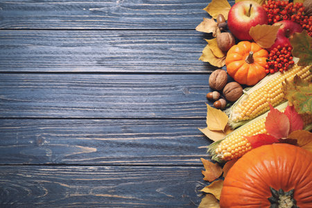 Flat lay composition with vegetables, fruits and autumn leaves on blue wooden table, space for text....