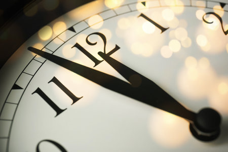 Clock showing five minutes till midnight with bokeh effect, closeup. New Year count down