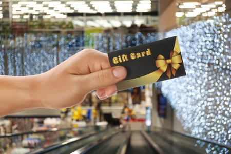 Man holding gift card in shopping mall, closeupの写真素材