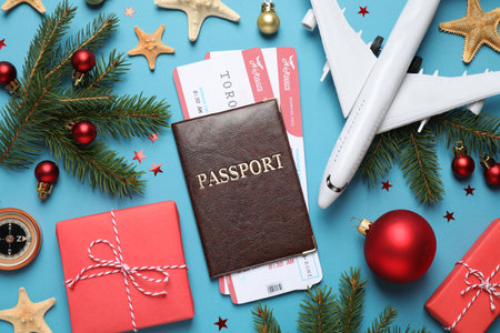 Flat lay composition with Christmas decorations, passport and airline tickets on blue background. winter holidaysの写真素材
