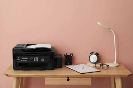 New modern printer and office supplies on wooden tableの写真素材