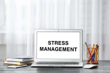 Laptop with text Stress Management on screen at workplaceの写真素材