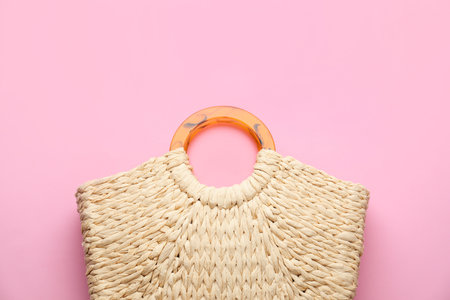 Elegant woman's straw bag on pink background, top viewの写真素材