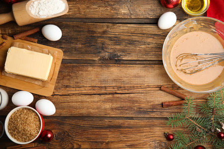 Flat lay composition with ingredients for traditional Christmas cake on wooden table. Space for text