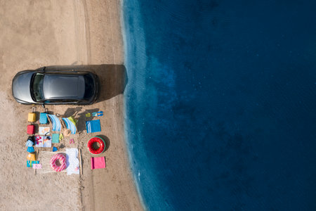 Car and beach accessories on sand near river, aerial view. summer tripの写真素材
