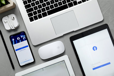 MYKOLAIV, UKRAINE - AUGUST 27, 2020: Flat lay composition with iPhone 11, MacBook laptop and iPad tablets on gray tableのeditorial素材