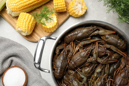 Fresh raw crayfishes in pot on gray table, flat lay