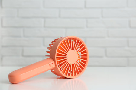 Portable fan on table near white brick wall. summer heatの写真素材
