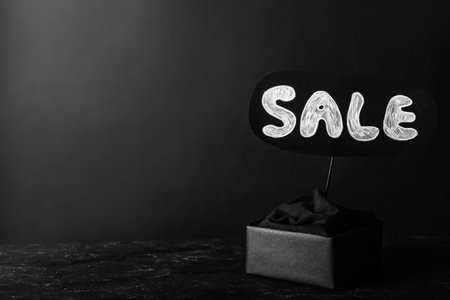 Package and card with word Sale on dark background, space for text. black friday conceptの写真素材