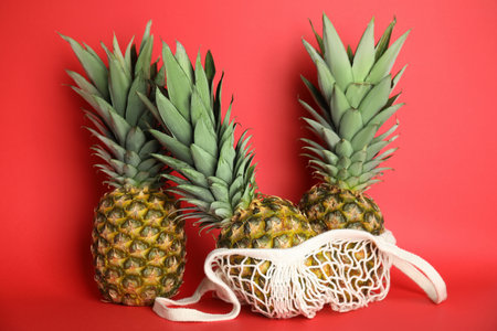 Fresh ripe juicy pineapples on red background
