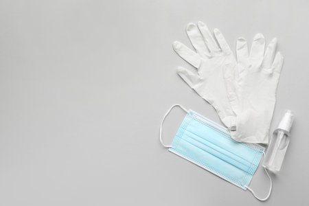 Medical gloves, protective mask and hand sanitizer on gray background, flat lay. Space for textの写真素材