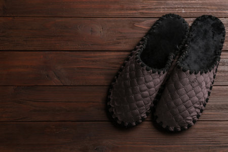 Pair of soft slippers on wooden background, flat lay. Space for textの写真素材