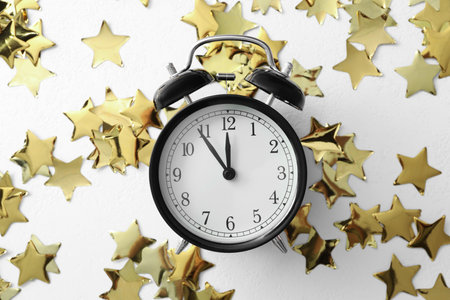 Alarm clock and Christmas decor on white background, flat lay. New Year countdown