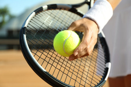Sportswoman preparing to serve tennis ball at court, closeupの写真素材