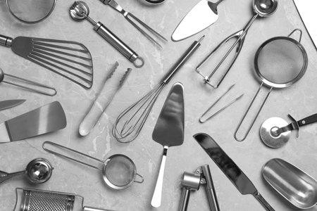 Cooking utensils on gray marble table, flat lay