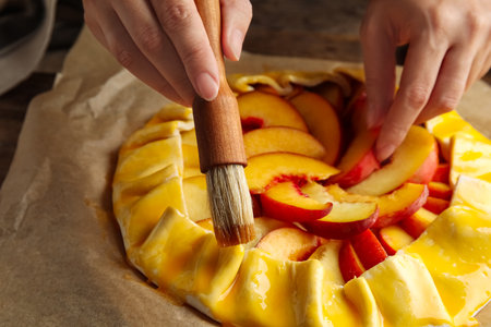 Woman making peach pie at table, closeupの写真素材