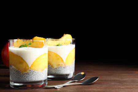 Tasty peach dessert with yogurt and chia seeds served on wooden table. Space for textの写真素材
