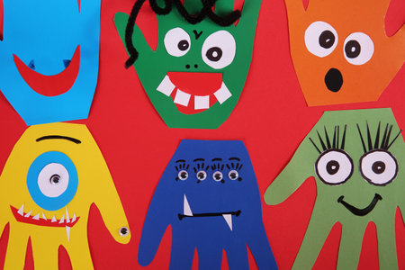 Funny hand shaped monsters on red background, flat lay. halloween decorationの写真素材