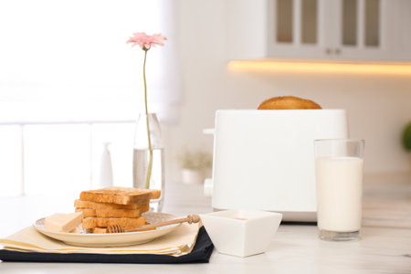 Modern toaster and tasty breakfast on white marble table in kitchenの写真素材