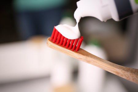 Applying toothpaste on brush against blurred background, closeupの写真素材