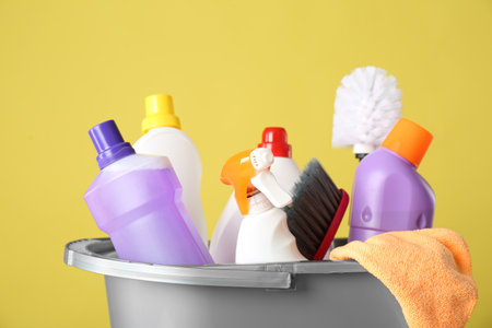 Bucket with cleaning products and tools on yellow background, closeupの写真素材