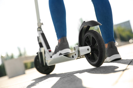 Woman riding electric kick scooter outdoors, closeupの写真素材