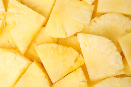 Slices of tasty ripe pineapple as background, top view