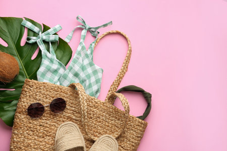Flat lay composition with woman's straw bag on pink background. Space for textの写真素材