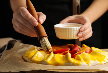 Woman making peach pie at table, closeupの写真素材