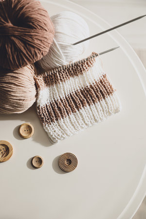 Yarn balls, buttons and knitting needles on white table, flat lay. creative hobbyの写真素材