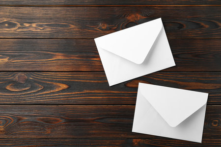 White paper envelopes on wooden background, flat lay. Space for textの写真素材