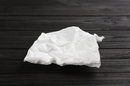 Crumpled paper napkin on wooden table. personal hygieneの写真素材