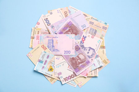 Ukrainian money on light blue background, flat lay