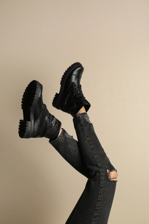 Woman wearing stylish boots on beige background, closeupの写真素材